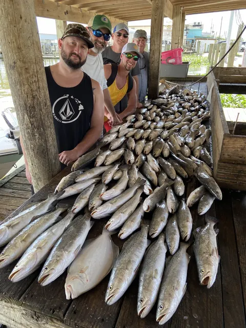 Anglers beside a day's catch of speckled trout on the cleaning dock in Venice, Louisiana