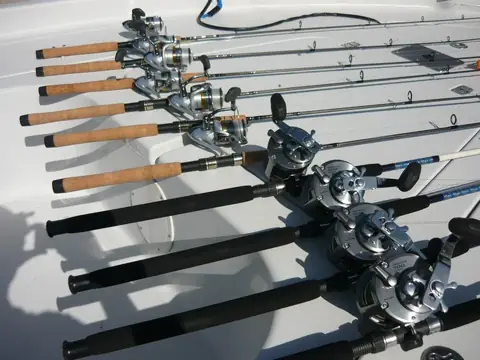 Baitcasting rods and reels laid out on the boat deck