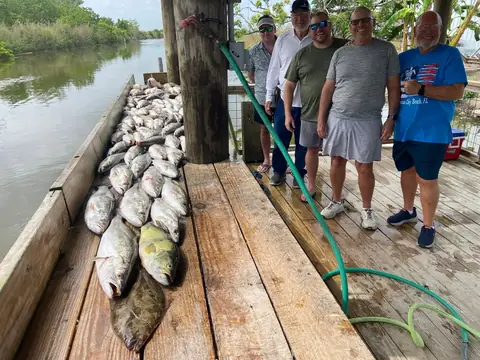 A group of anglers standing beside their catch on the dock in Venice, Louisiana