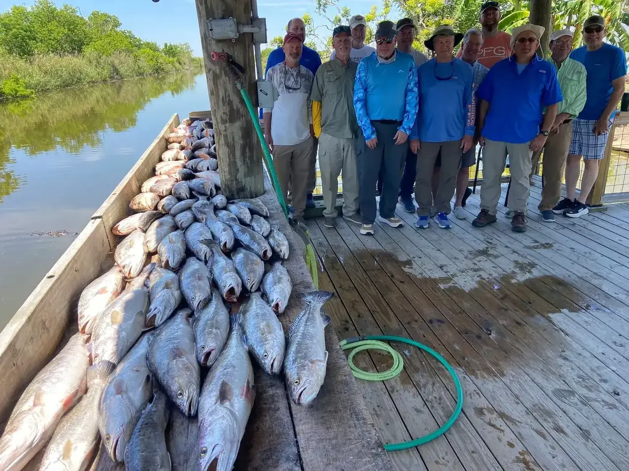 A group of anglers on the dock beside a day's catch