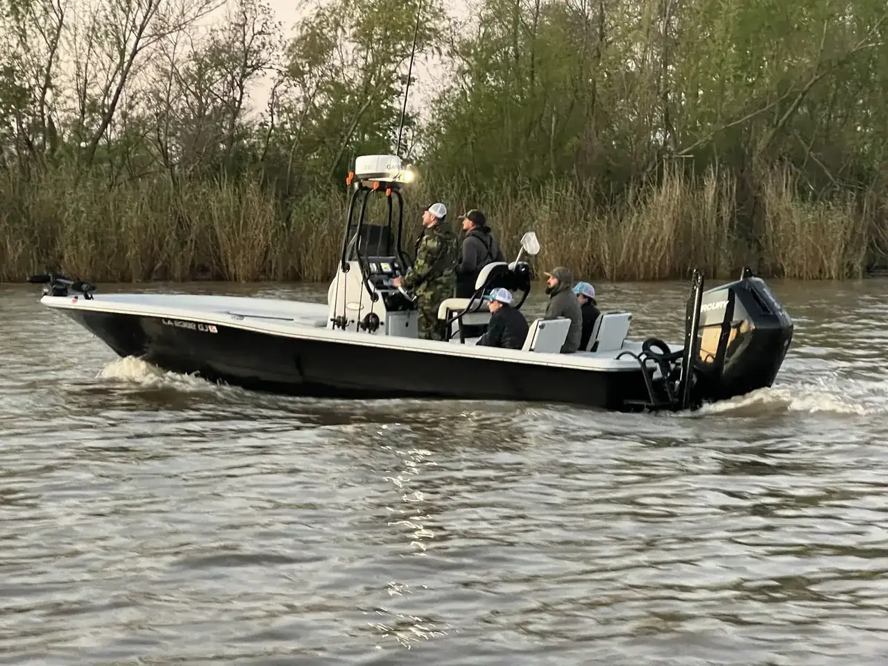 The Southern Delta Charters bay boat running along the cane with guests aboard